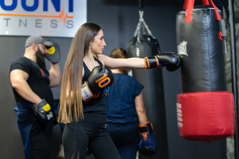 Girl punch the MMA bag with long hair